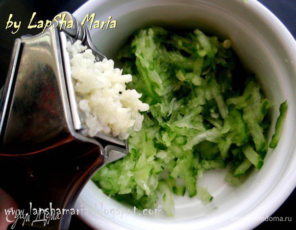 Отжимаем его как следует несколько раз, затем снова присолим. Выдавливаем  зубчики чеснока. 