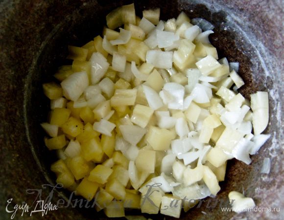 Пока готовится лук, очистить от семян перец и нарезать кубиками. Добавить к луку и тушить несколько минут. 