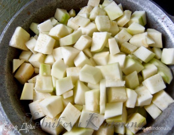 Пока тушатся овощи очистить кабачки от кожуры, нарезать на кубики. Добавить к овощам. Все перемешать и убавить огонь до минимума, накрыть крышкой и тушить 1 час, помешивая каждые 20 минут. 