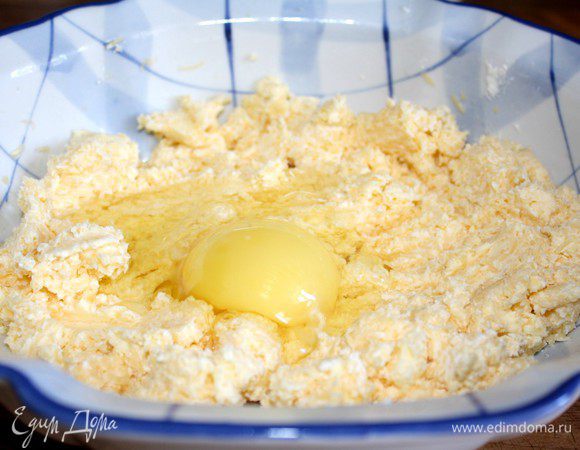 Сыр натереть на мелкой тёрке,смешать с маслом.Яйцо разделить на желток и белок.Желток добавить в тесто,а белок отложить.Смешать сырную смесь с мукой. 