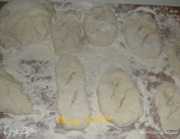 Сформируйте толстую колбаску из теста, нарежьте и, присыпая мукой, сформируйте пышки. Сделайте надрезы. Готовые пышки разложите на доске, присыпанной мукой.
