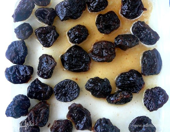 В смазанную сливочным маслом форму выложить чернослив и несколько минут прогреть в разогретой до 220 градусов духовке.