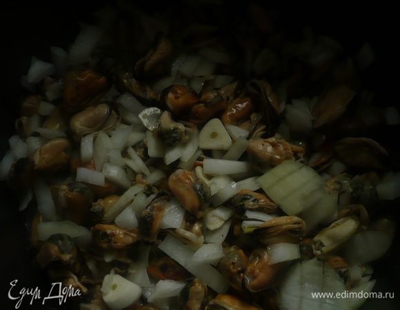 Нарезать мелко лук, чеснок дольками и добавить к мидиям через 10 минут