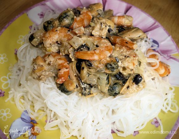 На рисовую лапшу выложить морепродукты, при желании можно посыпать сверху тертым сыром