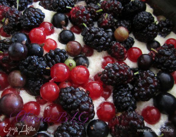 Один корж выложить в форму. Нанести 1/2 часть крема, ягоды. Накрыть коржом.