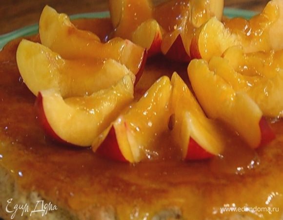 Готовый пирог выложить на тарелку, перевернув дном вверх, полить половиной сиропа, равномерно распределить его, выложить дольки нектаринов и полить оставшимся сиропом.