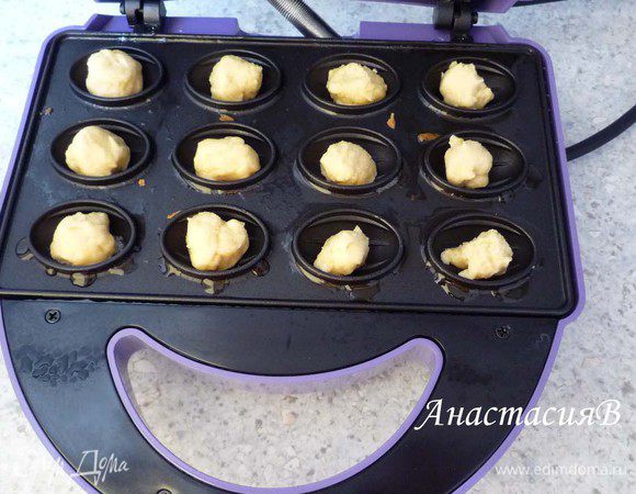 Разогреваем орешницу (у меня электрическая), немного смазываем маслом формочки. Пальцы смачиваем в воде и отщипываем от теста небольшие кусочки, формируем шарики и выкладываем в орешницу.