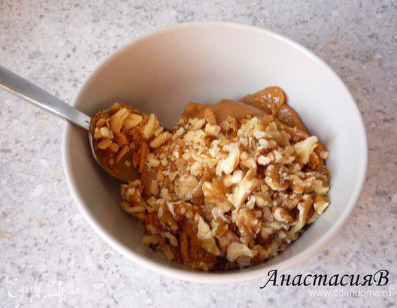 Добавляем к вареной сгущенке грецкие орешки и обрезки от теста, перемешиваем.