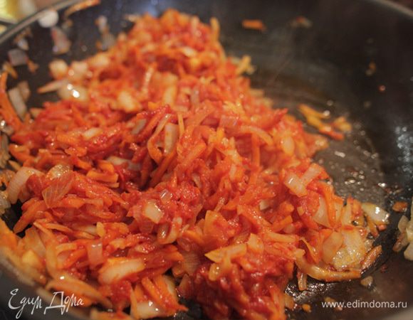 Убавьте огонь, добавьте томатную пасту, щепотку красного перца и мелко нарубленный чеснок, тщательно перемешайте, накройте крышкой и тушите еще 5 минут.