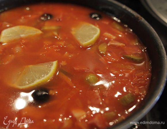 Доведите суп до кипения, убавьте огонь, закройте крышкой и варите еще минут 20–30. За 5 минут до снятия с огня, положите в солянку нарезанный лимон. Подавайте с зеленью.