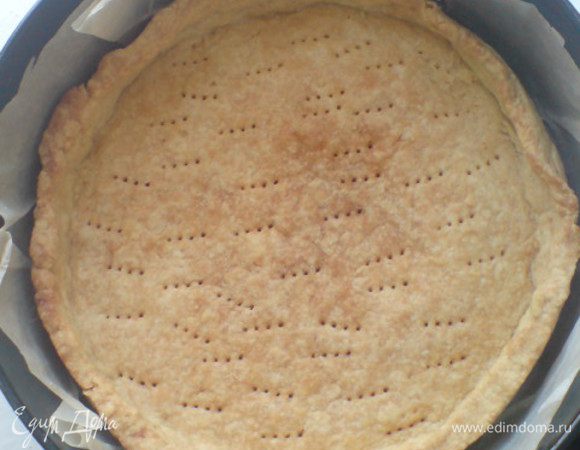 Тесто разделить на 2 части. Одну часть раскатать в пласт толщиной 0,5-1 см. Форму застелить бумагой для выпечки(маслом смазывать не рекомендую,т.к. в тесте достаточно много масла). Уложить тесто в форму,сделать небольшие бортики(высотой 2,5-3 см),попрокалывать вилкой и отправить в разогретую до 180 градусов духовку минут на 15-20. Затем остудить. Оставшуюся часть теста  отправить назад в холодильник или морозилку,из нее можно приготовить еще один пирог!