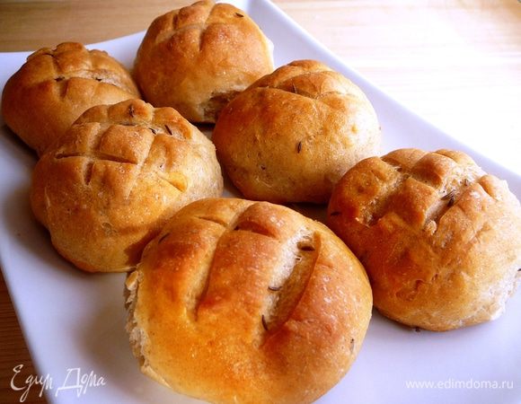 Накрыть льняным полотенцем и поставить на расстойку на 40-50 минут. По истечении этого времени сделать острым ножом  на булочках крестообразные надрезы.  Духовку предварительно разогреть до 220 градусов. Открыть духовку, обрызгать стенки водой и быстро посадить булки. Дверцу закрыть и выпекать 12-16 минут. 