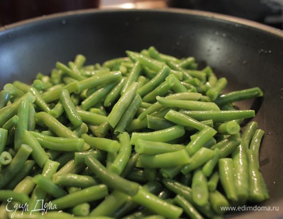 Зеленую фасоль выкладываем на сковороду с высокими бортами и тушим под крышкой с растительным маслом. Если фасоль свежая, то можно добавить немного воды. Если замороженная, то не надо.