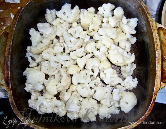 Цветную капусту разобрать на соцветия и бланшировать их в кипящей воде 2-3 минуты. Форму для запекания смазать слегка растительным маслом, выложить половину бланшированной капусты на дно. 