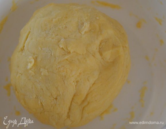 Тесто скатать в шар и переложить в разъемную форму (24 см). Распределить его руками по форме. Тощина коржа примерно 0,5 см, а высота бортиков 2 см.