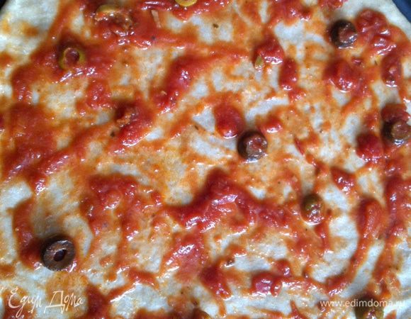 Смазать тесто томатной пастой.