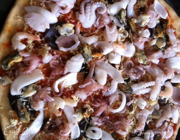 Выложить равномерно морепродукты. Поставить в предварительно разогретую до 200 градусов духовку минут на 20-25