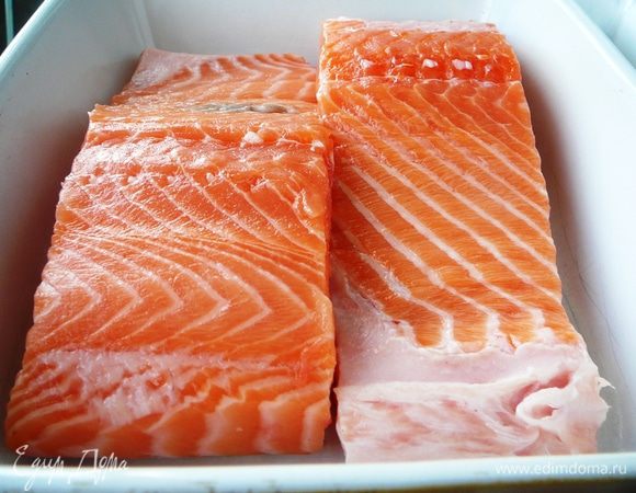 Положите рыбу в емкость кожицей вниз. Сбрызните коньяком.