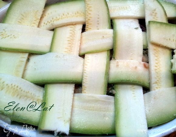 Дальше укладываем кабачки в виде плетенки, предварительно нарезанные вдоль на тонкие полоски. Сбрызнуть оливковым маслом и поставить в духовку на 20 минут. Духовку предварительно разогреть  до 220С.