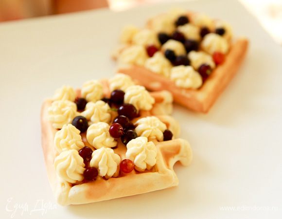 Взбить сливки с ванилином, сахаром.
Из шприца выдавить сливки на вафли.
Посыпать ягодами.