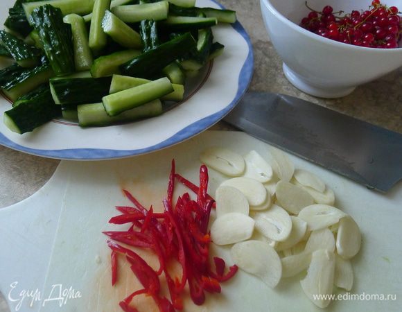 Красный жгучий перчик разрезаем по всей длине, удаляем семена, нарезаем тонкими полосками. 
Чеснок нарезаем красивыми тонкими пластинками.  