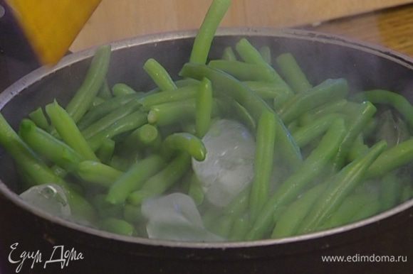 Слить воду в другую посуду, а фасоль поместить в емкость со льдом (можно даже перемешать со льдом), тогда она сохранит свой яркий зеленый цвет.