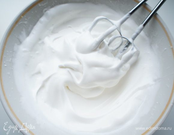 Белки достать из холодильника. Добавить к ним щепотку соли и взбить до появления пены. Затем не переставая взбивать всыпать сахар. Белки нужно взбить до устойчивых пиков.
