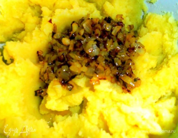 Превращаем картофель в пюре с помощью техники или старой доброй толкушки и отправляем к нему наш лук.