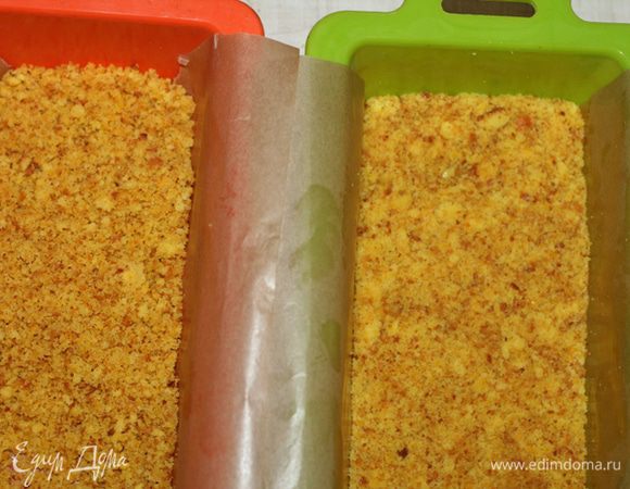 Форму застелить пергаментной бумагой, оставить края(для того чтоб потом можно было вытащить торт). Выложить бисквитную массу, равномерно утрамбовать и поставить в холодильник.