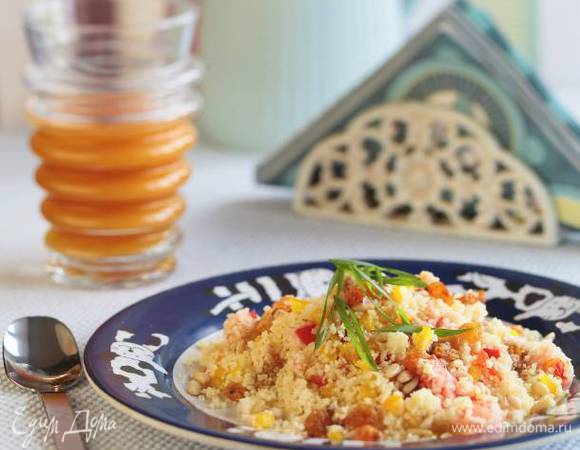 Полить кускус заправкой, перемешать, сверху посыпать кедровыми орехами, изюмом и зеленым луком.