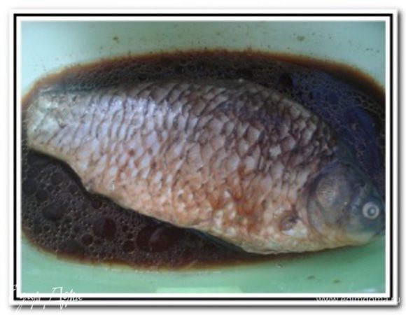 Замочить крапиву в кипятке. Карпа почистить, попотрошить и промыть. Посолить и поперчить снаружи и внутри. Соевый соус соединить с кунжутным маслом, натертым имбирем, специями для рыбы и сок 1/2 лимона. Положить карпа на 20 минут в соус.

