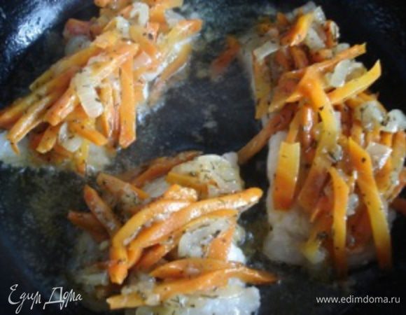 Перевернуть кусочки рыбы на другую сторону. Выложить сверху овощи. Добавить немного воды и тушить около 5 минут.