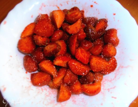 ...и нарезаем пополам или на четвертинки.Пересыпаем сахаром,можно сбрызнуть лимонным соком (но у нас и так ягода кисловатая!) и добавить для взрослых 1 ст.л.ликёра или коньяка. Клубника даст сок-это то,что нам надо! Можете тоже отправить её в холодильник до востребования.