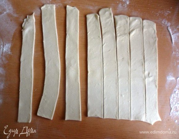 Раскатать слоеное тесто толщиной 3-4 мм. и нарезать длинные тонкие полоски