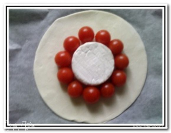 Вокруг сыра выложить помытые и обсушенные помидоры черри.