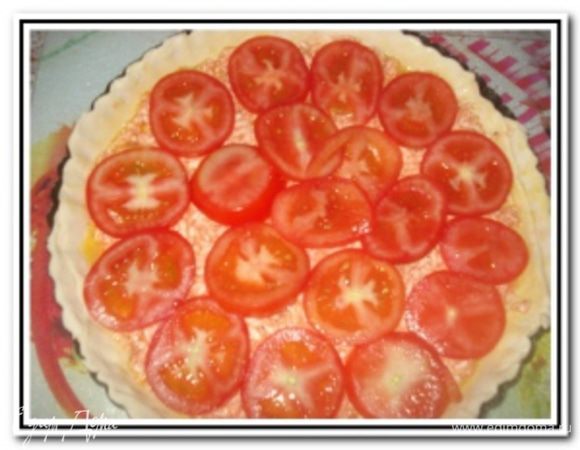 Помидоры вымыть, обсушить и нарезать кружочками. Выложить слоем на начинку помидоры.