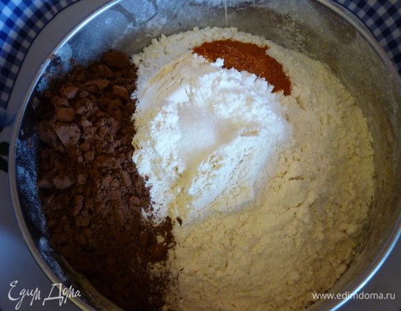 Пока шоколад и масло топятся, насыпьте в сито муку, какао, соль, разрыхлитель и перец чили. Не перемешивая просейте эту массу.