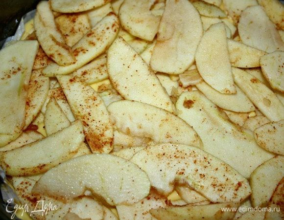 В смазанную форму вылить тесто, выложить ломтики яблок. Выпекать в хорошо разогретой духовке в течение 40-45 минут. Готовность яблочного пирога проверить деревянной шпажкой.