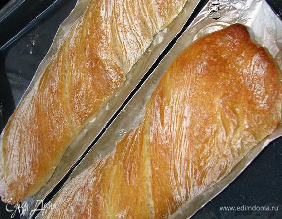Даем багетам "прийти в себя". Через 10 минут отправляем багеты в духовку, на самом нижнем уровне которой поставим противень с кипятком (200 мл). Температуру сразу уменьшаем до 220 градусов. Через 12 минут поворачиваем противень с багетами другой стороной (та что была ближе к дверце теперь будет у самой дальней стеночки духовки). Уменьшаем температуру до 200 градусов, выпекаем багеты еще 10-15 минут до красивой румяной корочки.