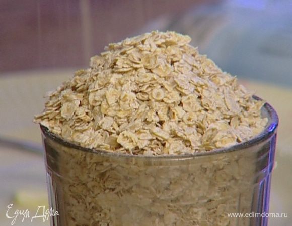 Добавить геркулес (немного хлопьев оставить), перемешать и выложить тесто на разделочную доску, присыпанную мукой. Вымешивать тесто до гладкости, чтобы оно не прилипало к рукам. Сформировать из теста шар и положить его в посуду, немного смазанную растительным маслом. Накрыть пленкой и поставить в теплое место. 