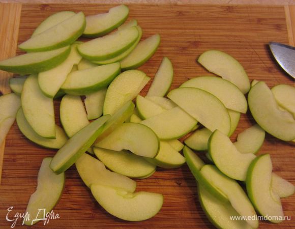 Разрежьте яблоки на четыре части, вырежьте середину. Обязательно проверьте, чтобы коробочки от семян не остались в яблоке, они могут испортить впечатление от пирога. Нарежьте яблоки сегментами толщиной от 3 до 5 миллиметров. Вы конечно можете обработать яблоки более привычным для вас способом. Главное, чтобы дольки были одинаковой толщины.
