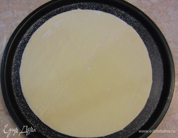 Для запекания я использовал форму для пиццы. Посыпьте сверху немного манной крупы, чтобы потом пирог легко снялся с нее. Выложите тесто поверх манки. Пирог немного потечет, если вы уложили довольно много начинки, поэтому можете сформировать из теста бортик, но я не стал этого делать. Проткните ножом тесто, чтобы оно не поднялось при запекании.