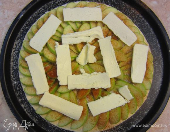 Уложите сверху яблоки. Дольки яблок укладывайте внахлест и старайтесь, чтобы кусочки были примерно одинакового размера. У меня получилось в два круга. Посыпьте сверху сахар и корицу и цедру апельсина. Я сыпал корицу через маленькое сито, таким образом корица распределяется более равномерно (хотя, конечно и не без косяков))). Выложите сверху кусочки сливочного масла. Запекайте в предварительно разогретой духовке до 200 градусов в течение 20-25 минут на нижней полке, чтобы тесто хорошо пропеклось.
Выложите пирог на блюдо.
Разогрейте джем до горячего состояния, чтобы он был жидким. Полейте джем поверх яблок зигзагами или по кругу. Лейте джем через сито, чтобы ни одно жесткое волокно не просочилось на идеальный пирог. Дайте остыть пирогу до слегка теплого состояния.