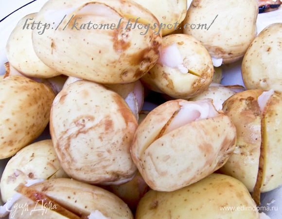 Молодой картофель промыть, слегка очистить от кожуры (если кожура совсем тонкая, то можно и оставить). Если картофель зрелый, то от кожуры очистить. Нарезать сало на тонкие полоски. Каждый клубень разрезать ножом вдоль, но не до конца и вложить по кусочку сала внутрь. 