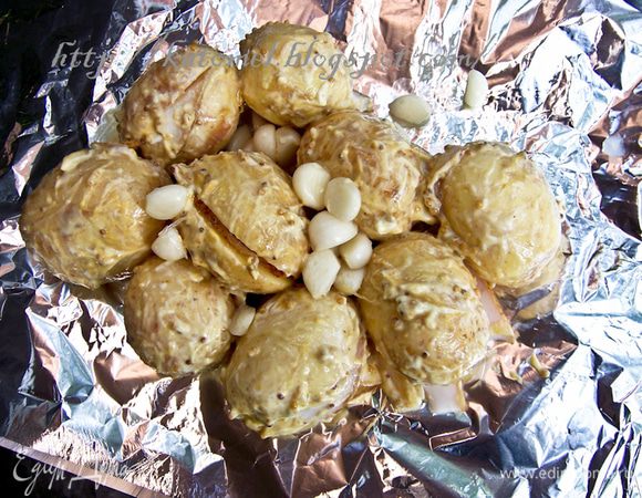 Мешать горчицу, майонез, соль, перец и очищенный чеснок. Добавить картофель и в глубокой таре перемешать руками, чтобы картофель был смазан соусом. Выложить картофель на прямоугольный лист фольги. Накрыть вторым листом и закрепить края, чтобы получился плотный конверт. Из 1 кг должно получиться два конверта. 