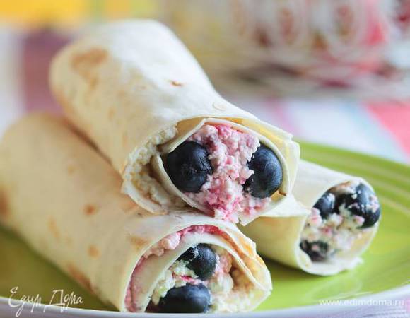 Выложить начинку на кусочки лаваша, капнуть немного меда и свернуть рулетиками. 