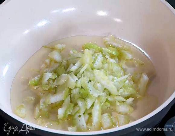 В большой сковороде с толстым дном разогреть растительное масло и обжарить лук до прозрачности, затем добавить сельдерей и чеснок и томить еще 3–4 минуты на небольшом огне.