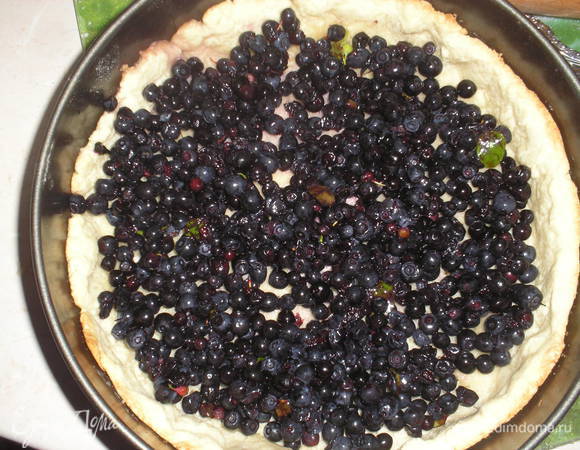 Наше слегка запеченное тесто вынимаем из духовки, снимаем груз, выкладываем чернику. Посыпаем сверху чернику сахаром.
