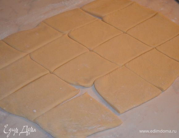 Раскатать тесто в пласт размером 20 х 40 см и нарезать на прямоугольники. У меня получилось 16 штук. Каждый скатать в рулетик. 