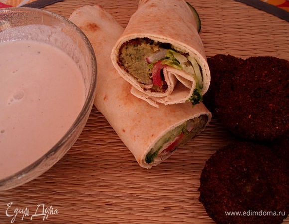 Подают фаляфель с овощами как свежими,так и с солеными,а также с кунжутным соусом.Фаляфель заворачивают с овощами в питу,поливают соусом.Приятного аппетита.Извините за качество фото,они были сделаны давно.